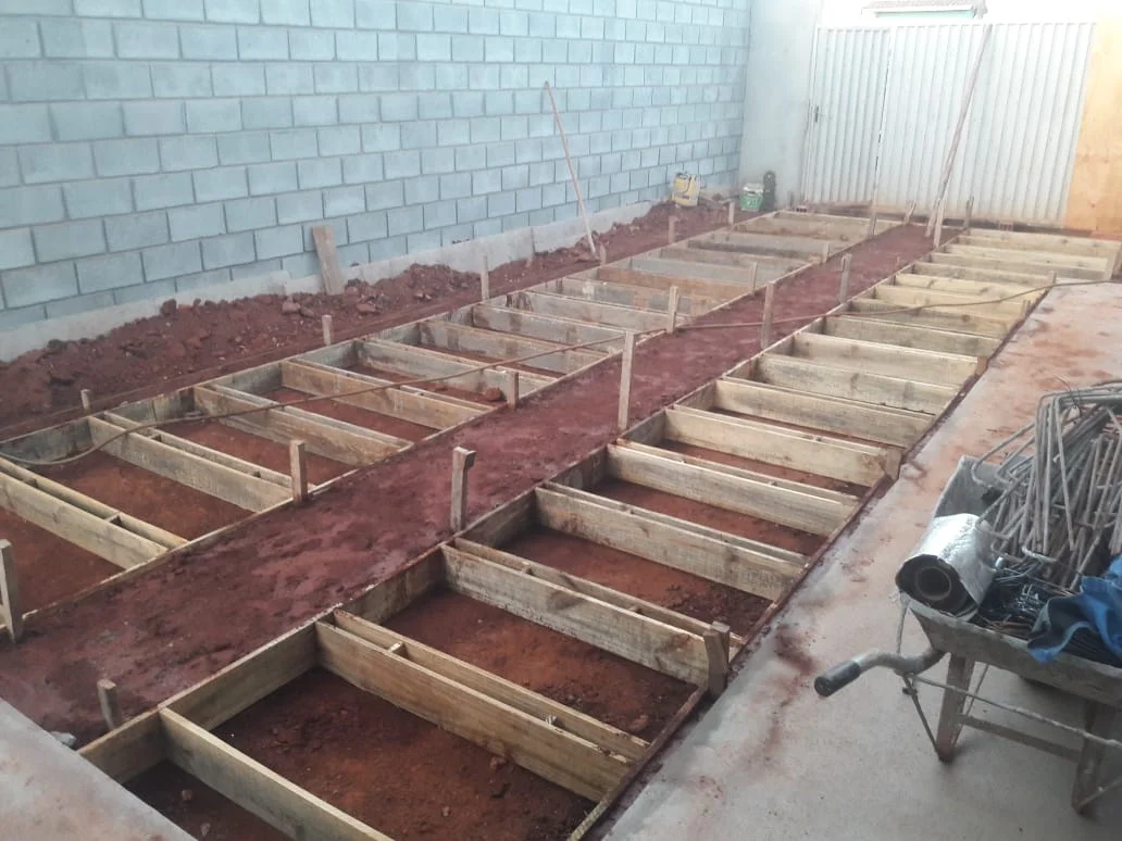 Original construction photo of the same house showing timber formwork preparation beside an exposed block wall