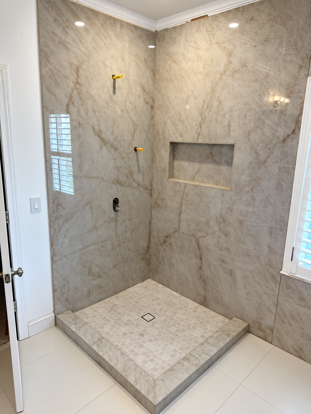 Stone shower tile and floor installed before fixtures are fitted